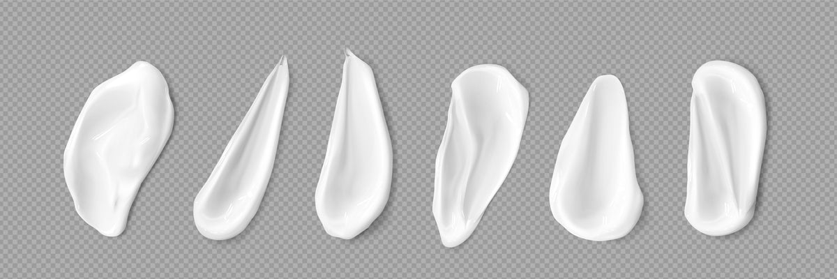 Six white cream smears of different shapes laid out on a transparent chequered background